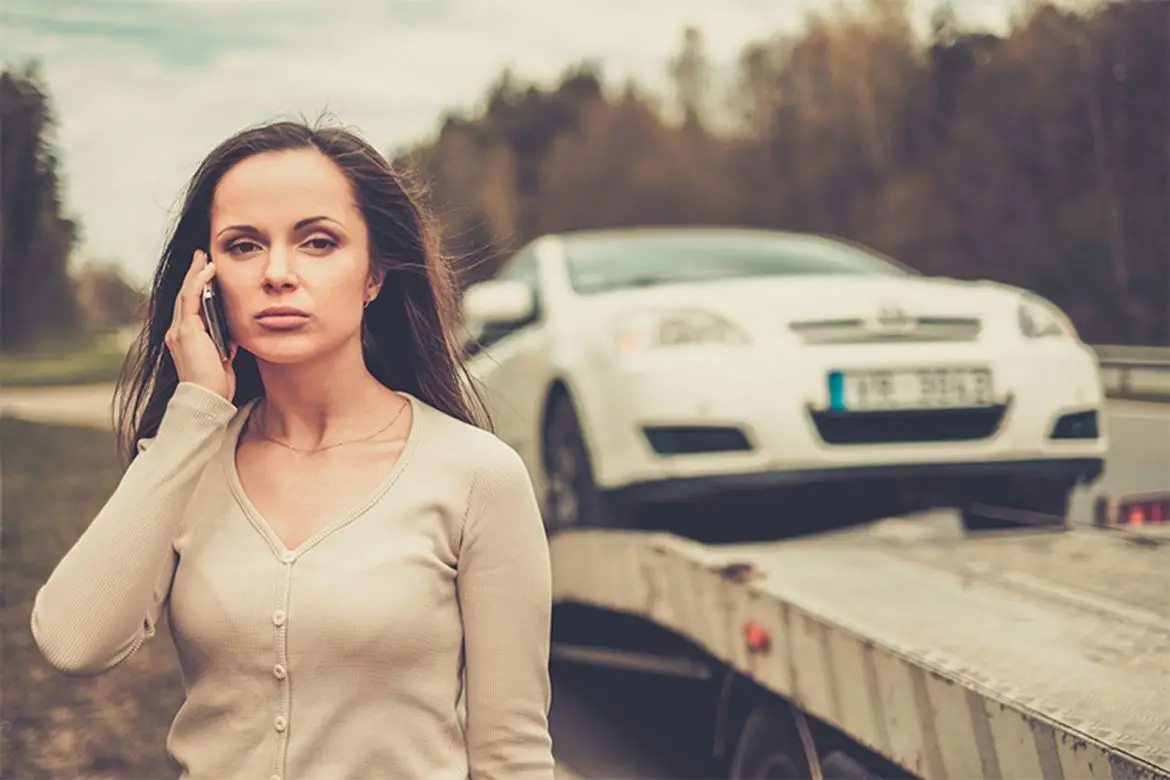 Une femme désespérée est en panique au téléphone, appelant, et cherchant de l'aide pour dépanner remorquer sa voiture